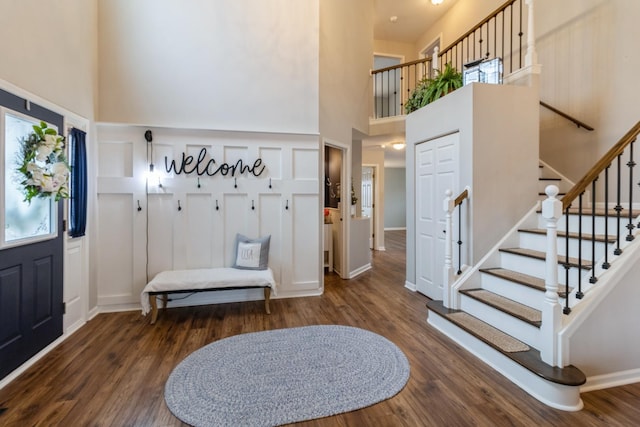 foyer featuring stairway, a high ceiling, and wood finished floors