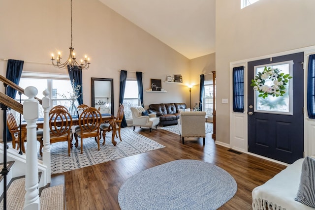 entrance foyer featuring visible vents, dark wood-type flooring, stairs, high vaulted ceiling, and a notable chandelier