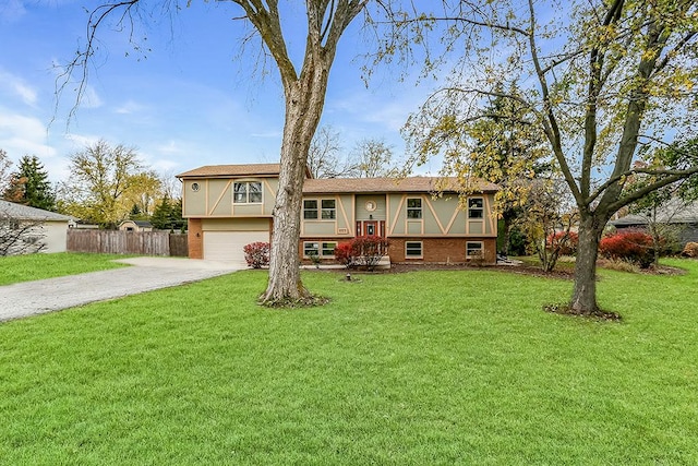 bi-level home featuring an attached garage, brick siding, fence, driveway, and a front yard