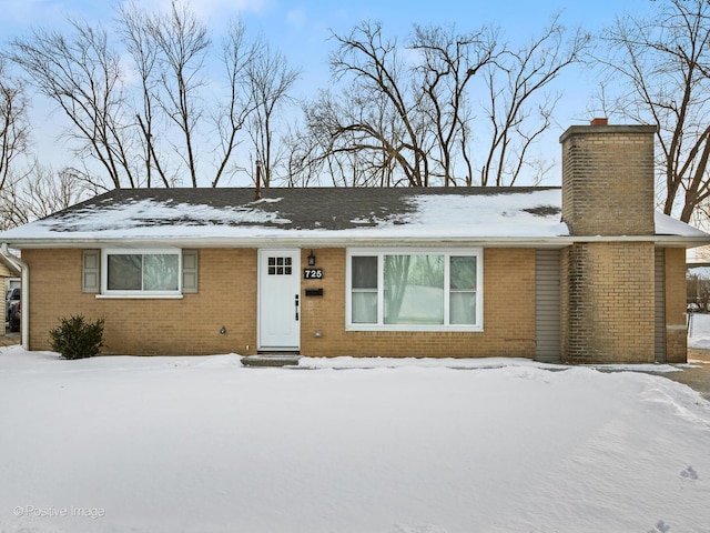 single story home with brick siding and a chimney