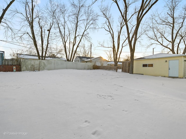 yard covered in snow with fence