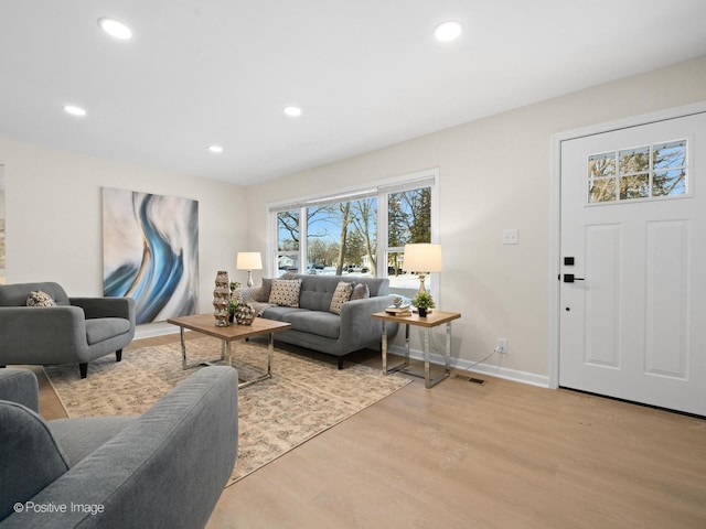 living area with recessed lighting, baseboards, visible vents, and light wood finished floors