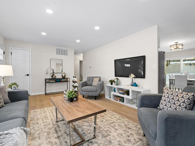 living area with light wood-style floors, baseboards, visible vents, and recessed lighting