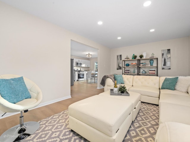 living room with baseboards, wood finished floors, and recessed lighting