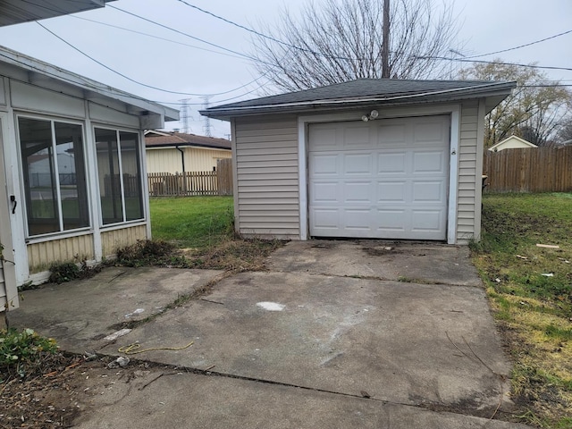 detached garage with driveway and fence