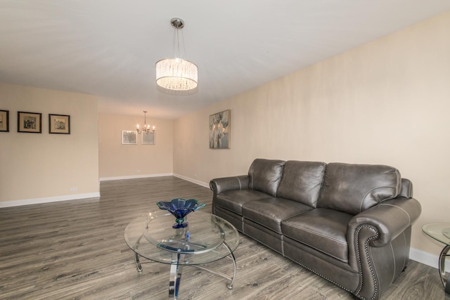 living area featuring wood finished floors, baseboards, and an inviting chandelier