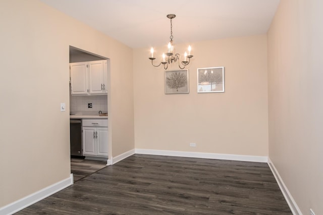 unfurnished dining area featuring dark wood-style floors, an inviting chandelier, and baseboards