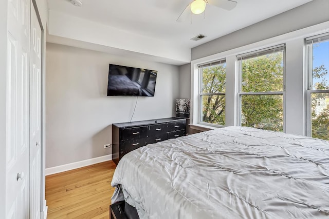 bedroom featuring ceiling fan, wood finished floors, visible vents, and baseboards