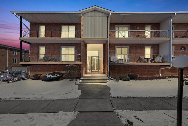 view of front facade with brick siding and a balcony