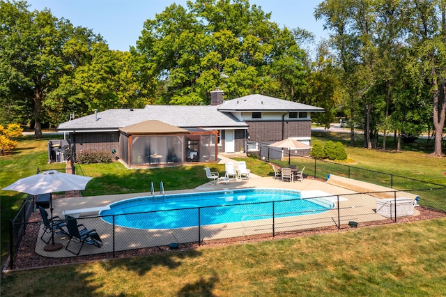 view of swimming pool featuring a lawn, fence, a gazebo, a fenced in pool, and a patio area