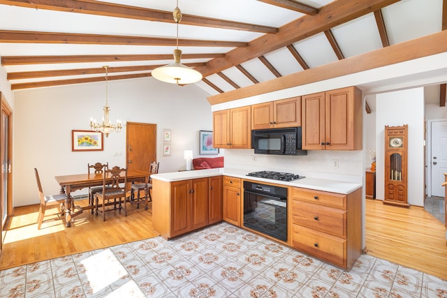 kitchen with a peninsula, black appliances, light countertops, decorative light fixtures, and a notable chandelier