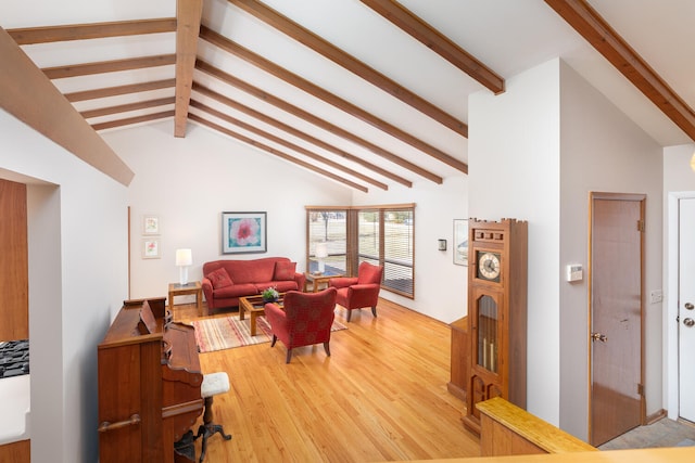 living area featuring light wood-style floors and vaulted ceiling with beams