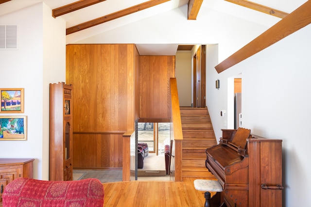 interior space with lofted ceiling with beams and visible vents