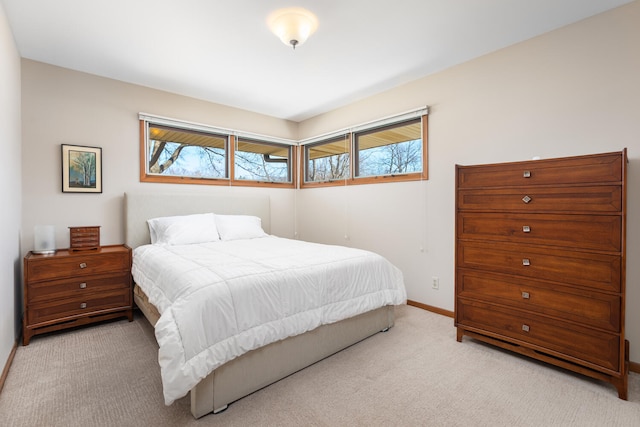 bedroom with multiple windows, light colored carpet, and baseboards