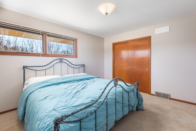 carpeted bedroom featuring baseboards, visible vents, and a closet