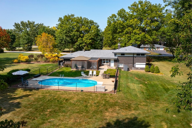 view of swimming pool with a patio, a yard, fence, and a fenced in pool