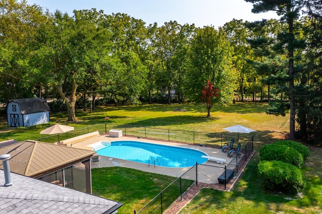 view of pool featuring a lawn, fence, a storage shed, an outdoor structure, and a fenced in pool