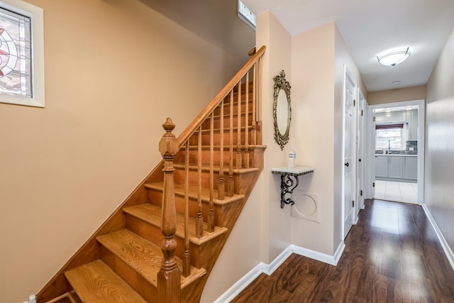 staircase with wood finished floors and baseboards