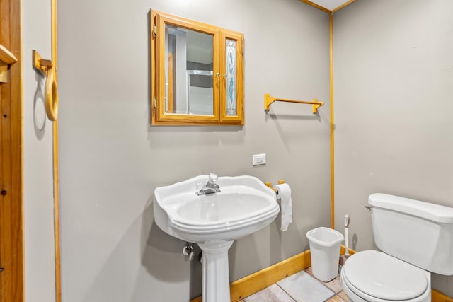 bathroom with tile patterned flooring, toilet, and baseboards