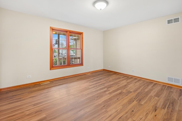 spare room with baseboards, visible vents, and light wood-style floors