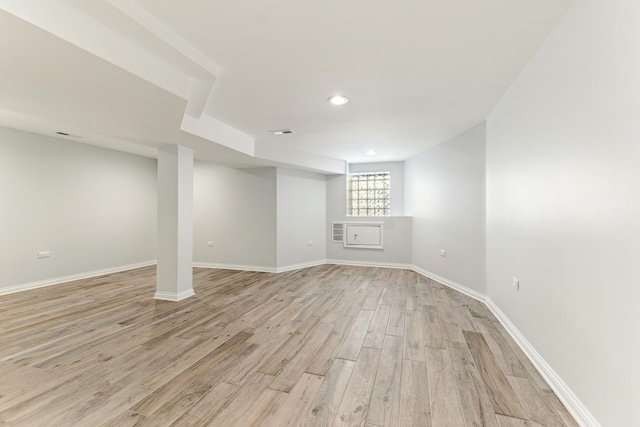 basement featuring light wood-type flooring, baseboards, and visible vents