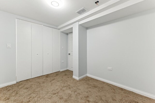 unfurnished bedroom with a closet, baseboards, visible vents, and carpet floors