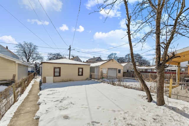 view of front of property with a detached garage, an outdoor structure, and fence