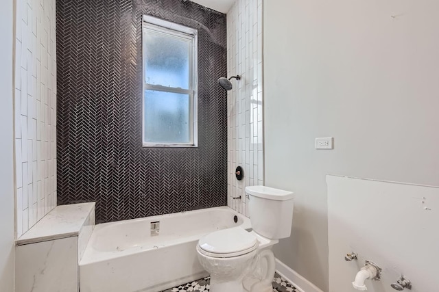 bathroom featuring baseboards, toilet, and tub / shower combination