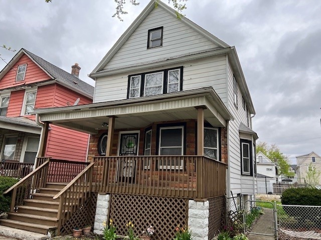 american foursquare style home with a porch and fence