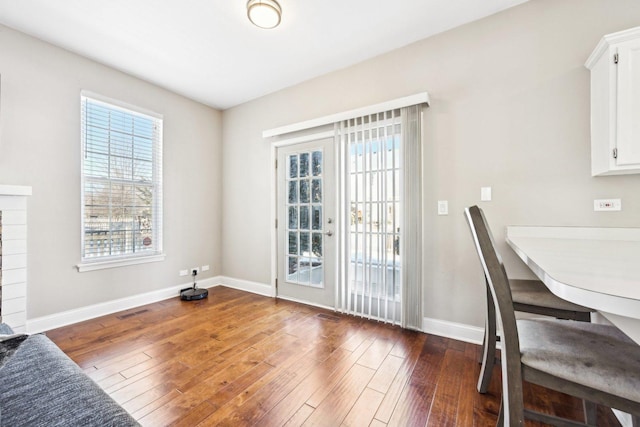 interior space featuring wood-type flooring, visible vents, and baseboards