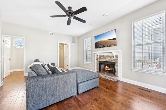 living area featuring wood-type flooring, visible vents, and baseboards