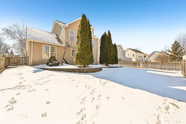 view of front of house with a chimney, fence, and a residential view