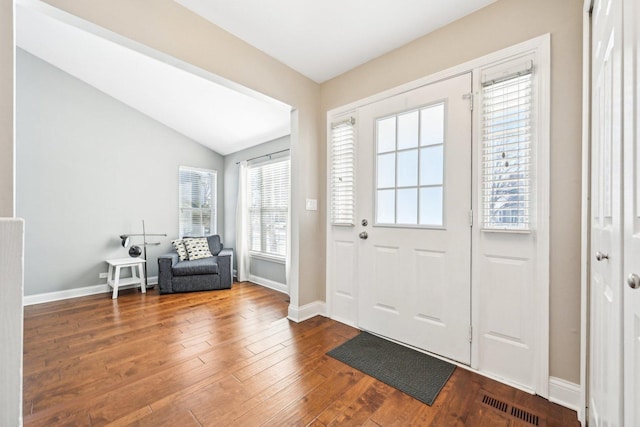 entryway with lofted ceiling, baseboards, visible vents, and hardwood / wood-style floors