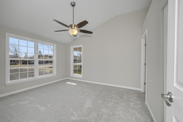 spare room with light carpet, vaulted ceiling, and baseboards