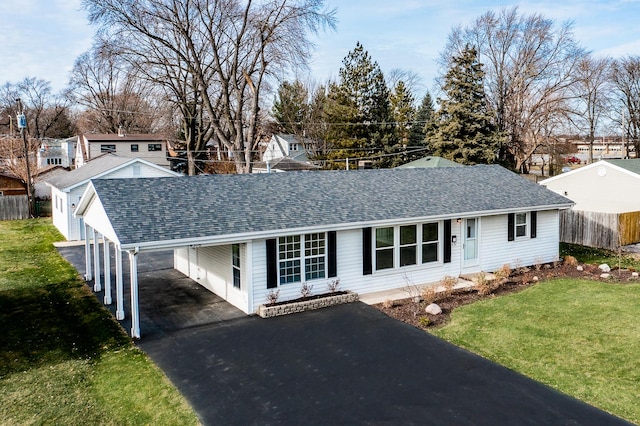 ranch-style home featuring a carport, roof with shingles, driveway, and a front lawn