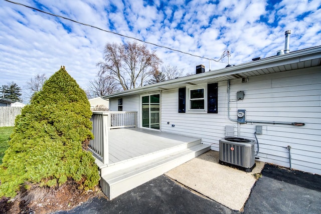 exterior space with a deck, a chimney, and cooling unit