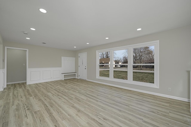 unfurnished living room featuring a wainscoted wall, light wood-style flooring, and recessed lighting