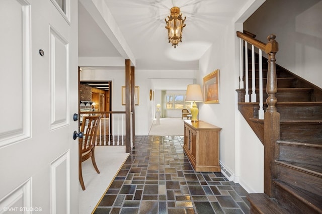 entrance foyer with stairway and stone finish floor