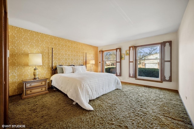 carpeted bedroom with wallpapered walls and baseboards