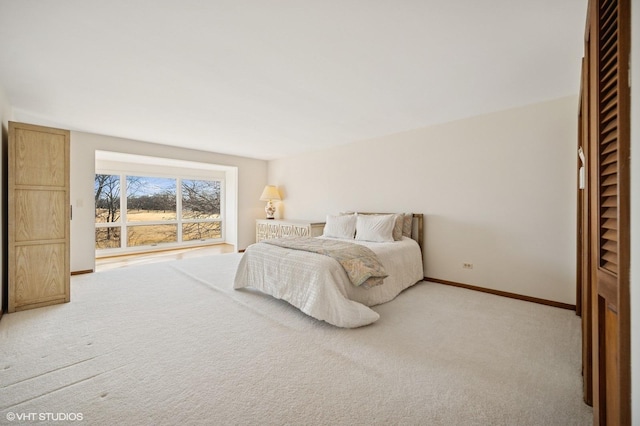 bedroom with light carpet and baseboards