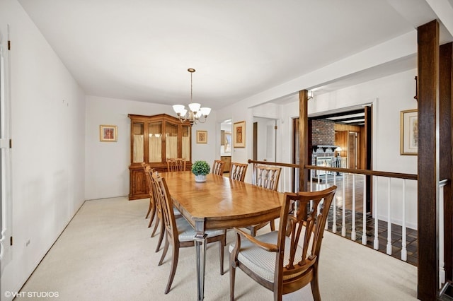 dining area with an inviting chandelier and light carpet