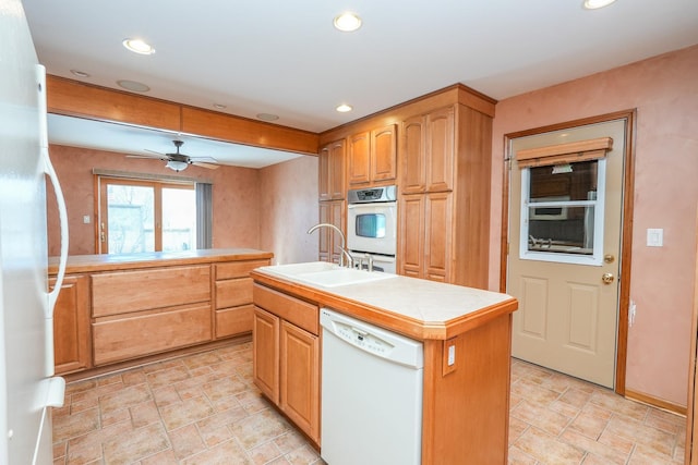 kitchen with white appliances, tile counters, a kitchen island with sink, a sink, and recessed lighting