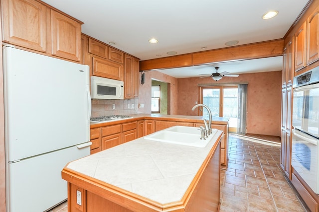 kitchen with an island with sink, tile countertops, appliances with stainless steel finishes, and a sink