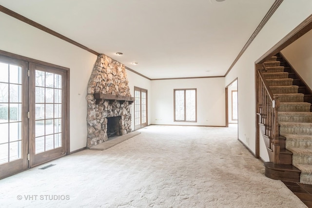 unfurnished living room with a fireplace, visible vents, stairway, ornamental molding, and carpet flooring