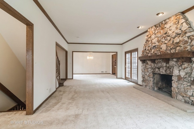 unfurnished living room featuring ornamental molding, baseboards, light colored carpet, and a stone fireplace