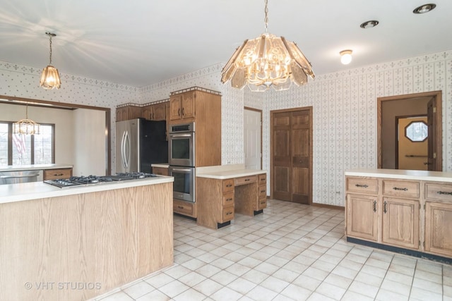 kitchen with appliances with stainless steel finishes, a chandelier, light countertops, and wallpapered walls