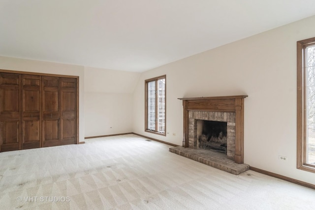 unfurnished living room featuring plenty of natural light, carpet, and baseboards