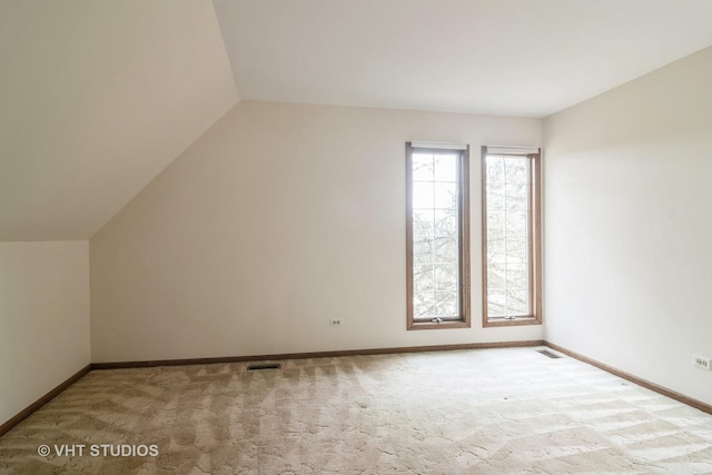 additional living space featuring lofted ceiling, carpet floors, visible vents, and baseboards