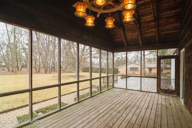 unfurnished sunroom featuring vaulted ceiling with beams