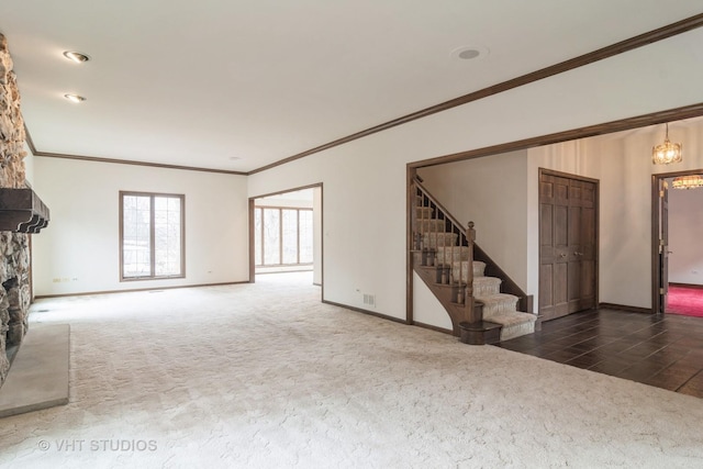 unfurnished living room with carpet floors, ornamental molding, baseboards, and stairs